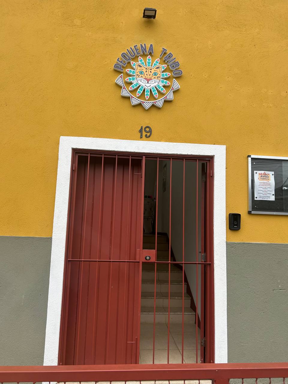 Fachada da sede da Pequena Tribo, com o brasão do Pequeno Jaguá sobre a porta de entrada.